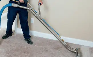 Professional operating a liquid removal machine on a carpeted floor in Des Moines, IA